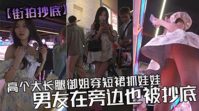 【街拍抄底】高个大长腿御姐穿短裙抓娃娃，男友在旁边也被抄底，白色透明内内，从前面抄底能看见y毛